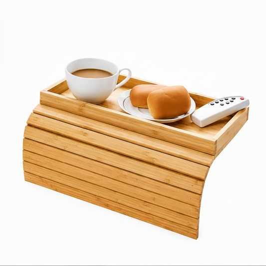 A bamboo TV tray with a curved front, shown holding a white coffee cup, a small plate with two rolls, and a white remote control, on a plain white background.
